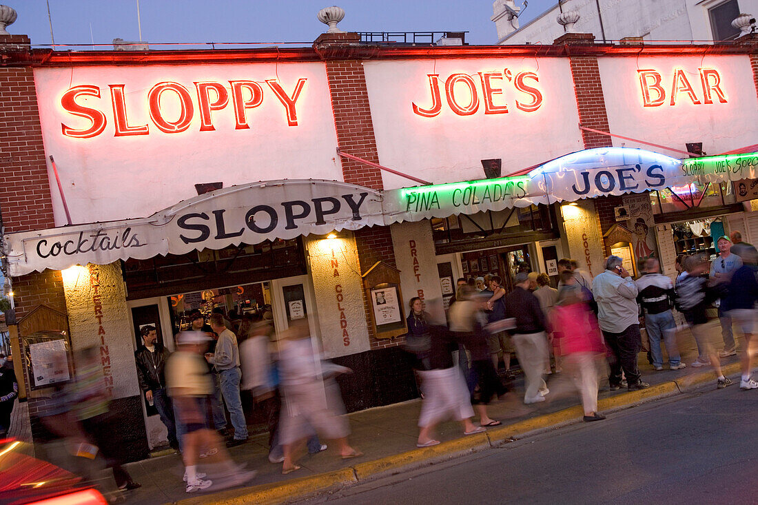Menschen stehen abends vor Sloppy Joes Bar in der Duval Street, Key West, Florida Keys, Florida, USA