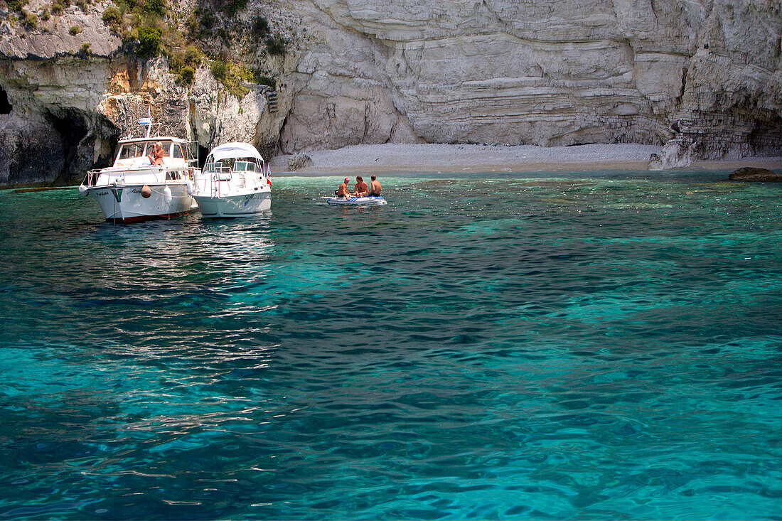 Boote ankern vor den Höhlen an der Westküste, Paxos, Ionische Inseln, Griechenland