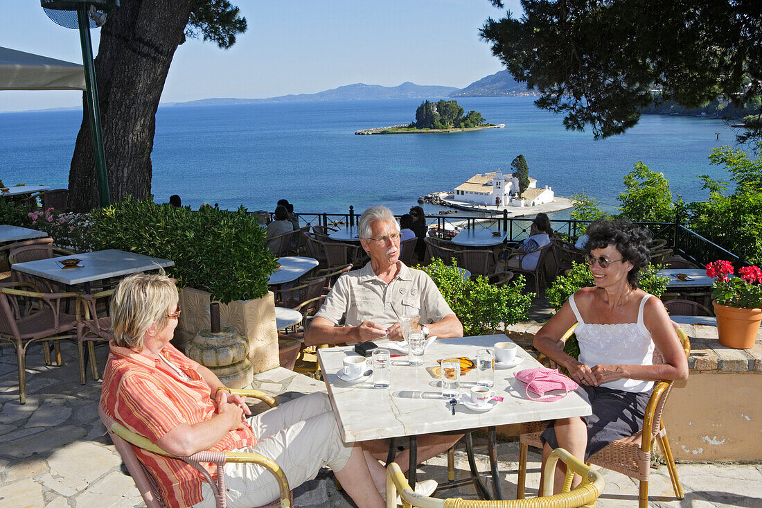 Menschen sitzen auf der Terrasse des Café Kanoni, Korfu, Ionische Inseln, Griechenland