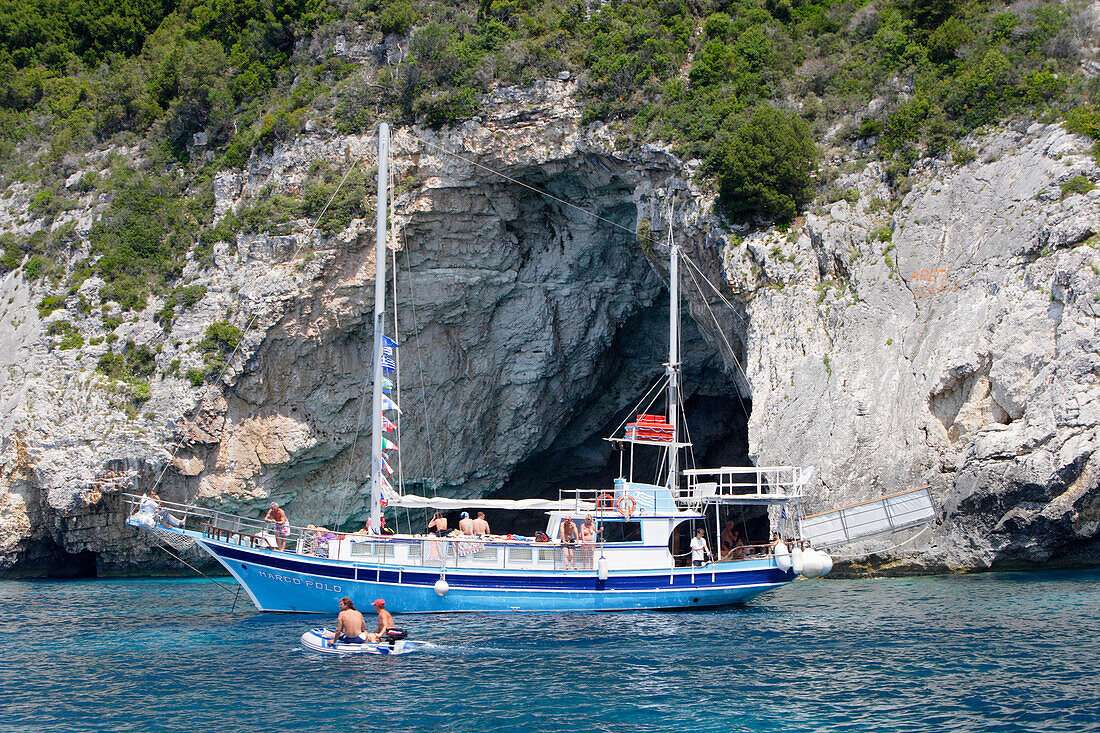 Paxos, Menschen fahren in Booten vor Höhlen an der Westküste, Ionische Inseln, Griechenland