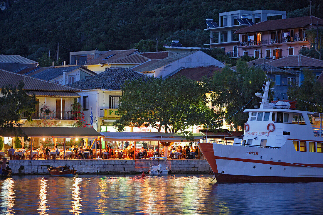 People sitting in a tavern at the harbour of Vasiliki in the evening, Lefkada, Ionische Inseln, Greece