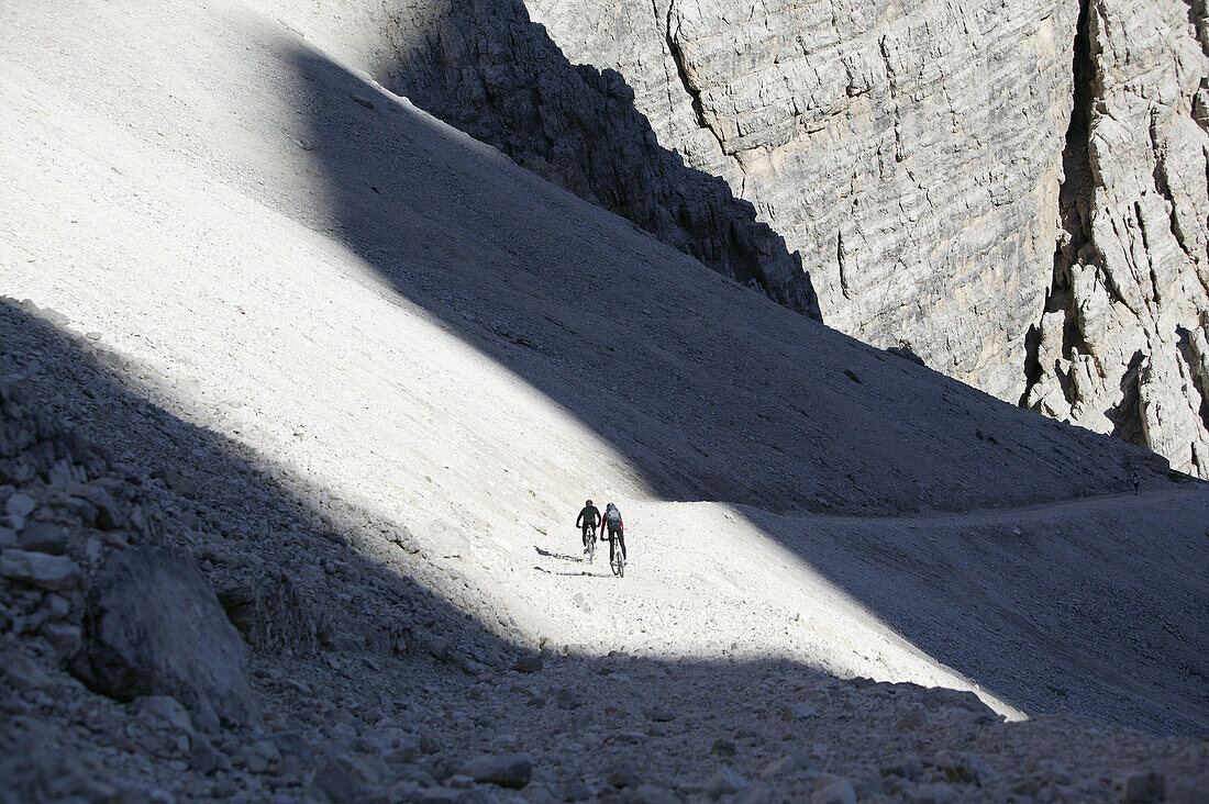 Mountain bikers on mountain path, Tofane, Dolomites, Veneto, Italy