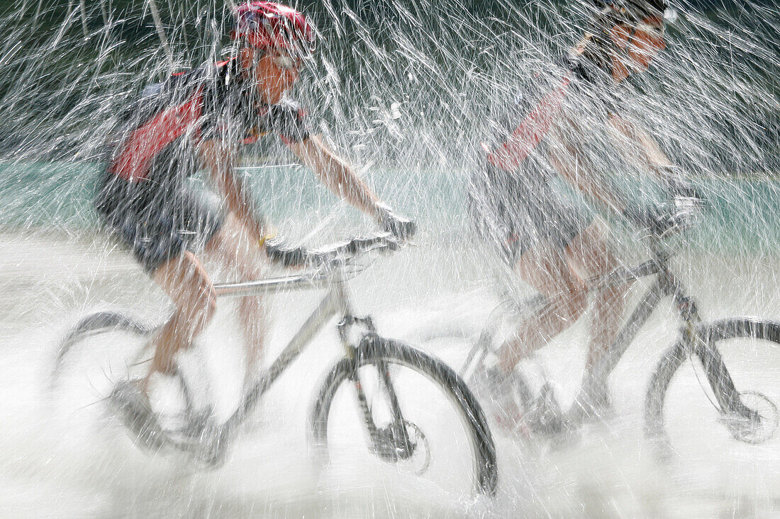 Mountainbiker fahren durch Toblacher See, Trentino-Südtirol, Italien