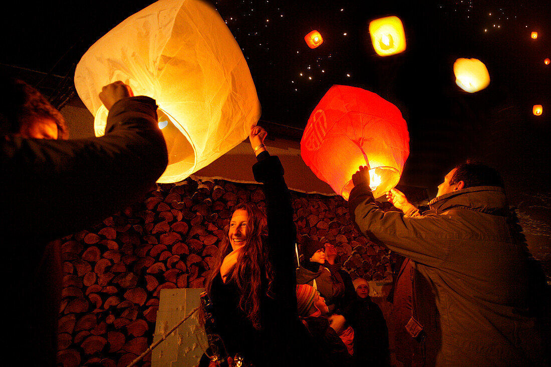 People lighting skylaterns on new year, Munsing, Bavaria, Germany
