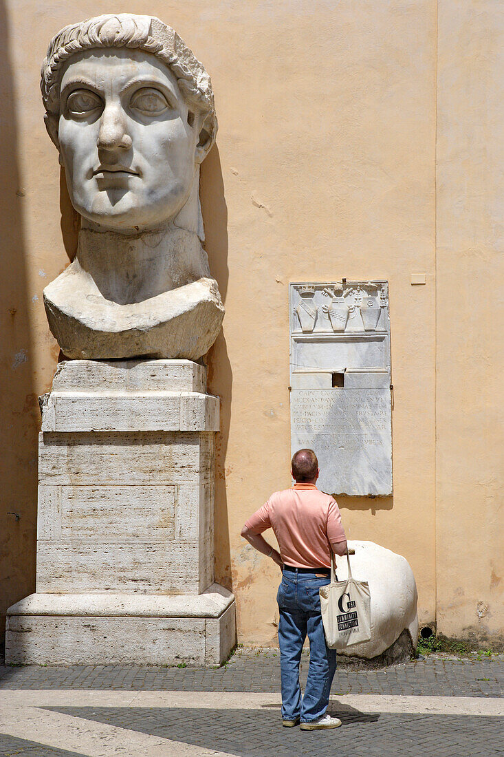 Tourist in front of the head of Constantine, Capitoline Museums, Palazzo dei Conservatori, Rome, Italy, Europe