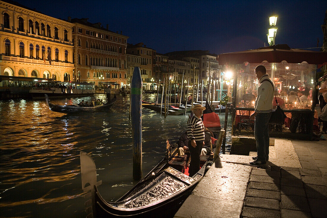 Nachtaufnahme von Gondoliere mit Gondel am Canal Grande, Venedig, Venetien, Italien, Europa