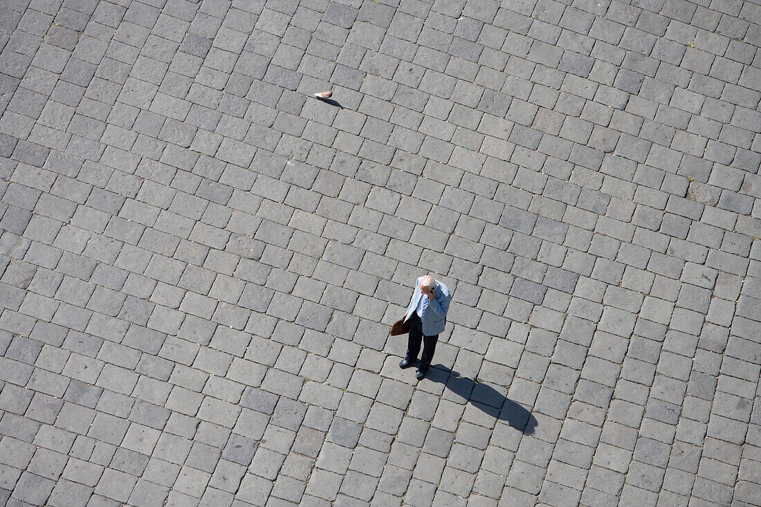 Man on Piazza talking on his mobile phone, seen from Duomo Clock Tower, Messina, Sicily, Italy