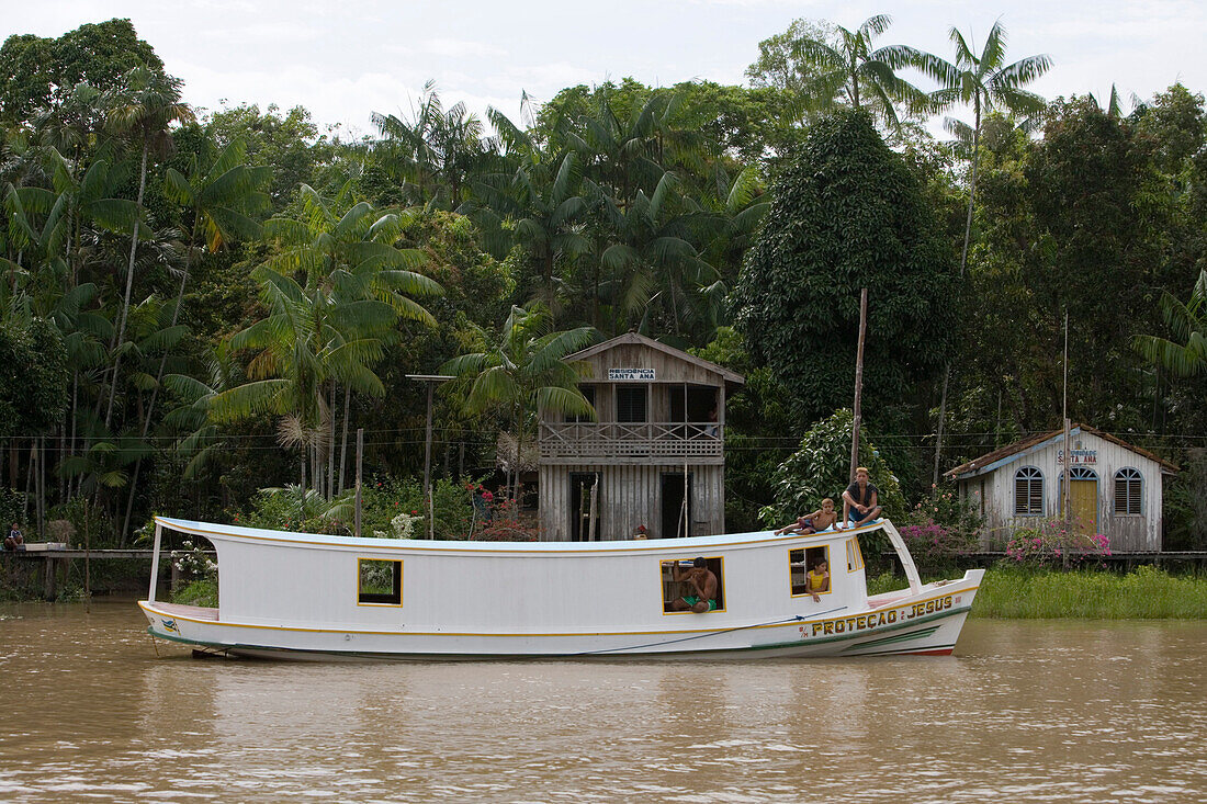Boat and houses along the riverbank on a branch of the Amazon River, Rio do Cajari, Para, Brazil, South America