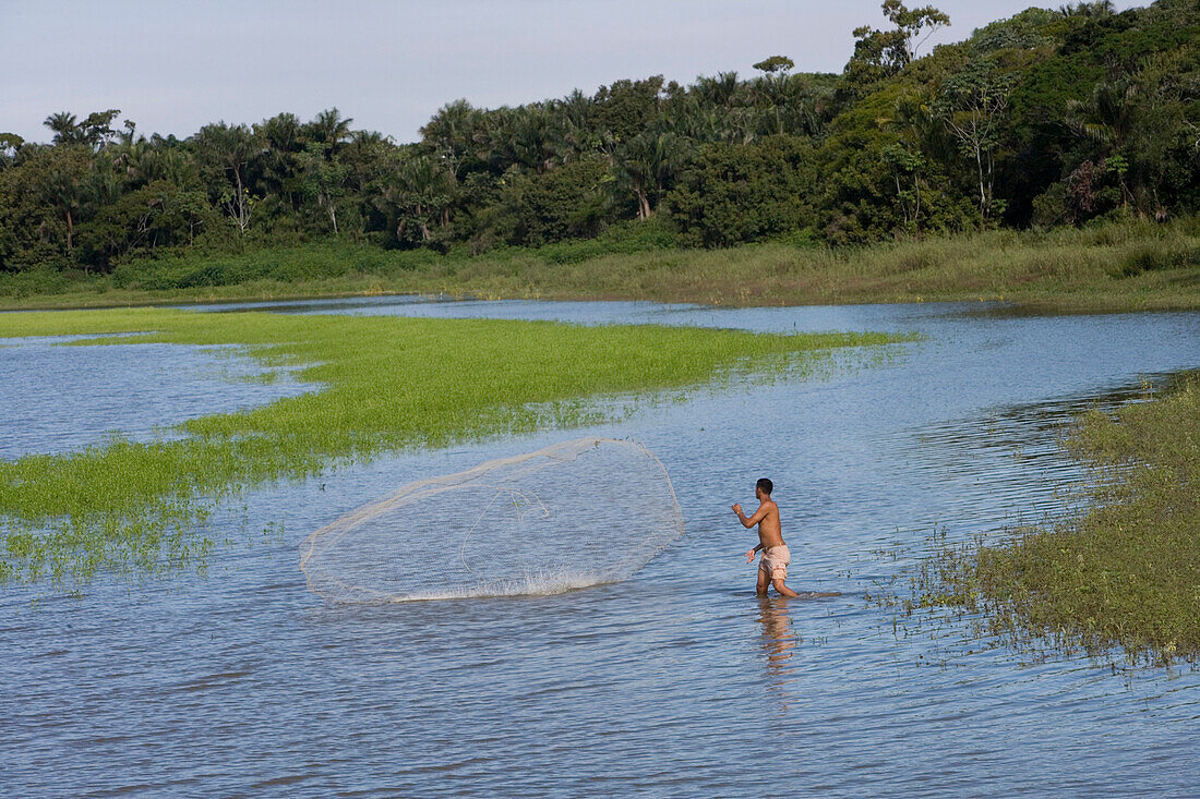 Fisherman throws out fishing net on Rio Tapajos, Near Santarem, Para, Brazil, South America