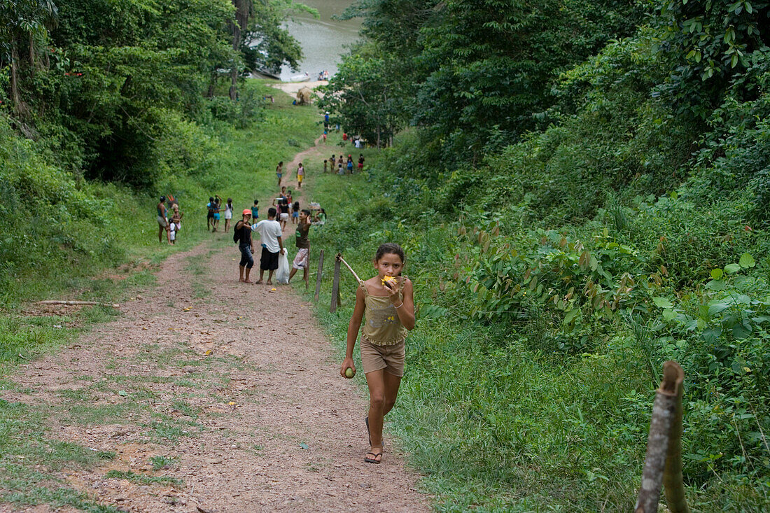Mädchen frisst Mango in Dorf im Amazonas Regenwald, Boca da Valeria, Amazonas, Brasilien, Südamerika