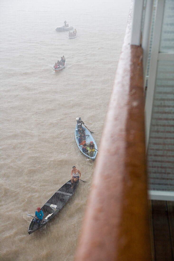 Railing of MS Europa and Amazonian Indians in canoe during a rain downpour on the Amazon River, Boca da Valeria, Amazonas, Brazil, South America