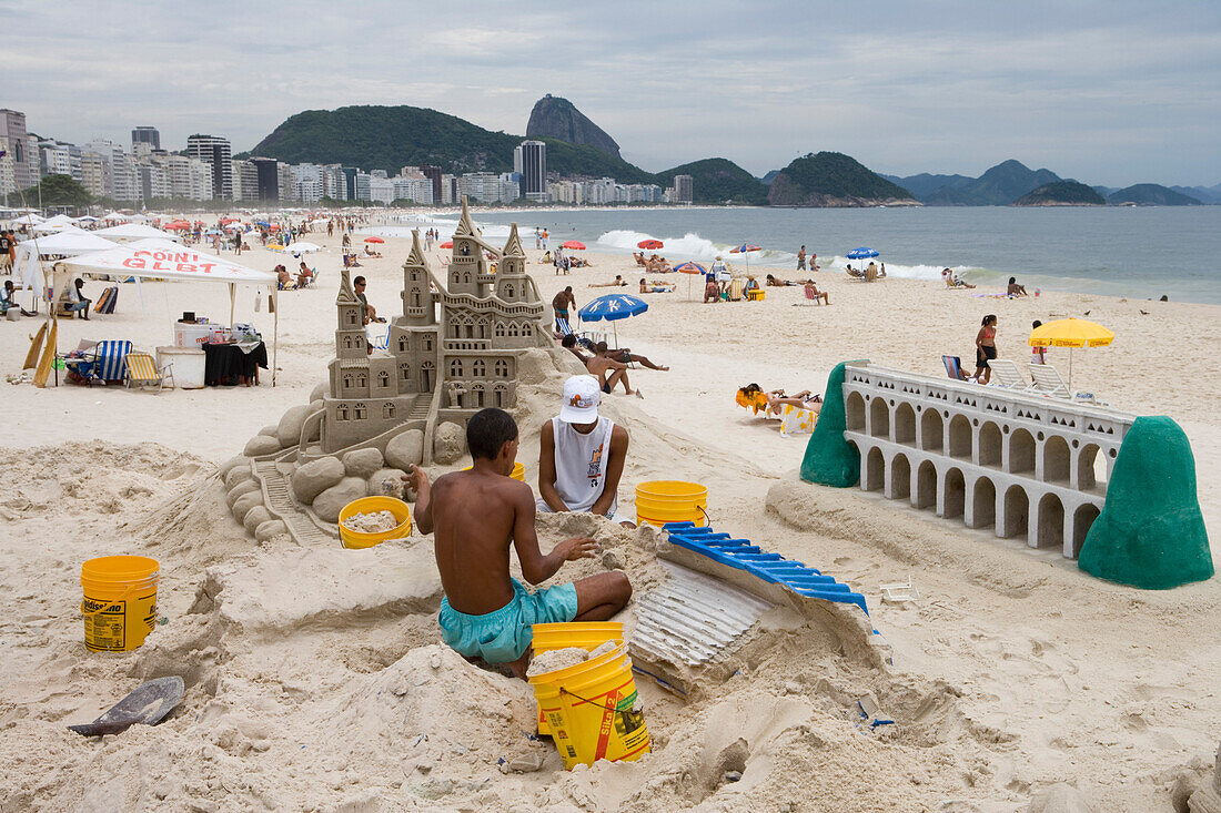 Men building sand castles on Copacabana Beach, Copacabana, Rio de Janeiro, Brazil, South America