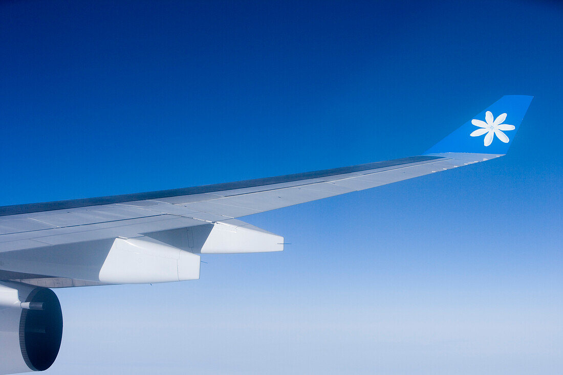 Aerial photo of Air Tahiti Nui Airbus A340 wing with Tiare flower logo on wingtip, French Polynesia