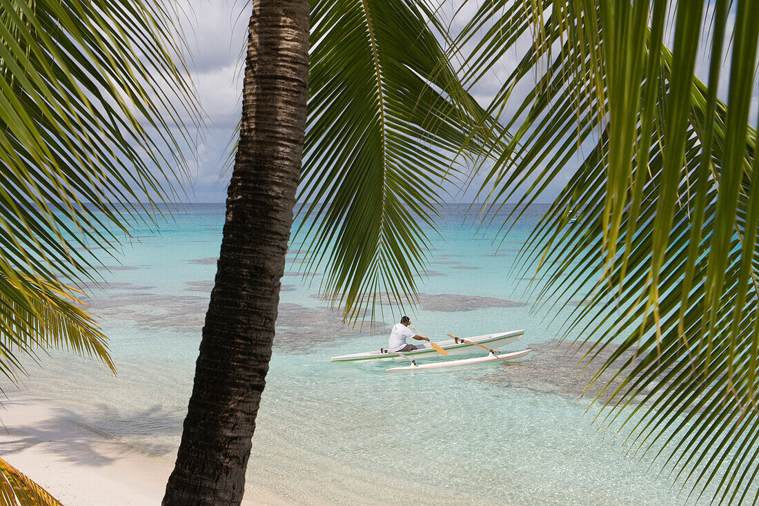 Man on outrigger canoe paddling in Fakarava Lagoon, Fakarava, The Tuamotus, French Polynesia