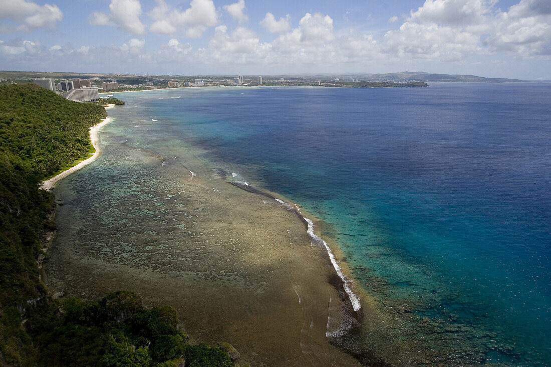 Blick von oben auf Tumon Bucht mit Gun Beach unter Wolkenhimmel, Guam, Mikronesien, Ozeanien