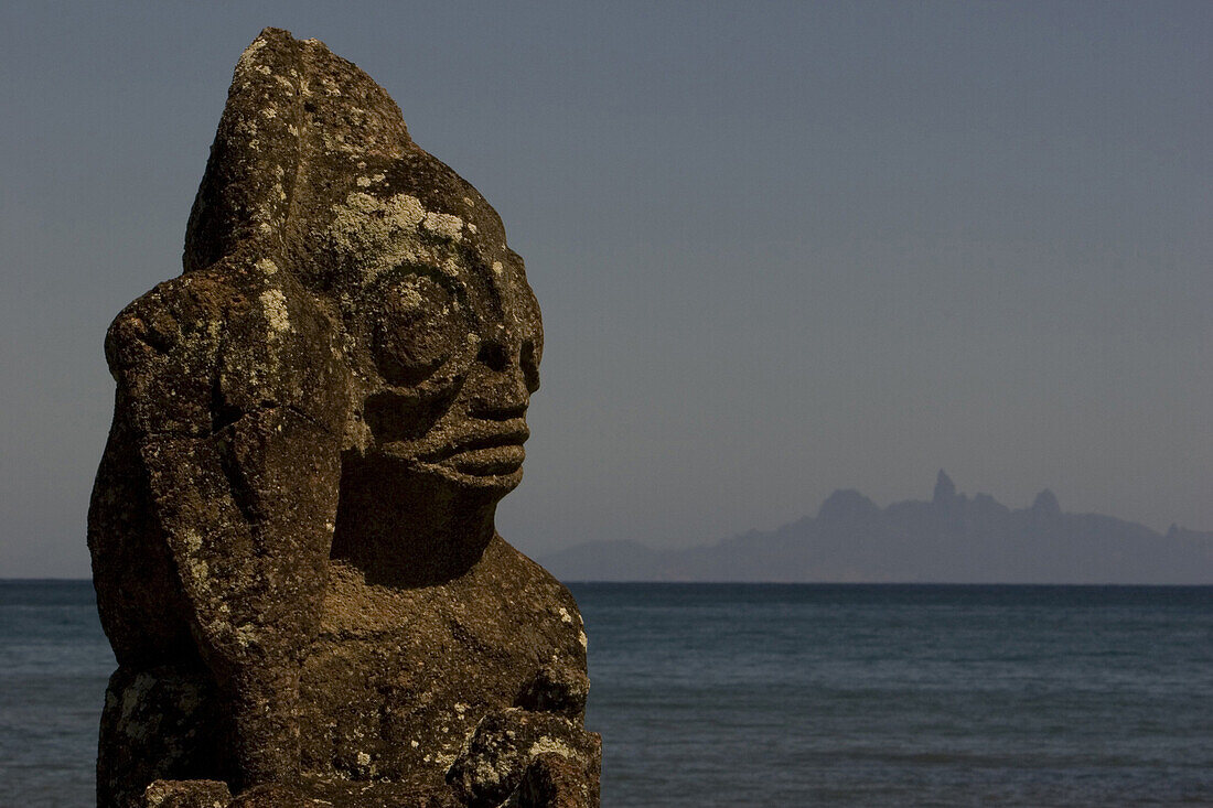 Tiki, weathered stone figure in front of Ua Pou island, Marquesas, Polynesia, Oceania