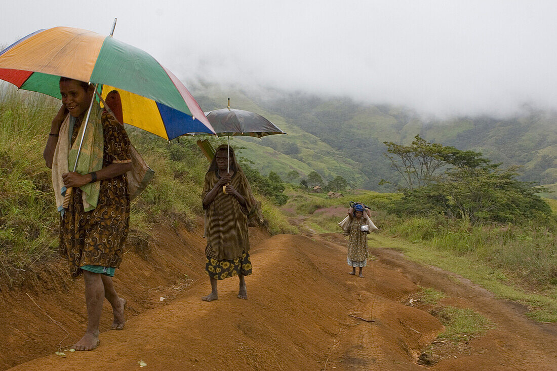 Frauen gehen auf Pfad mit Schirm, Langila, Hochland, Papua Neuguinea, Ozeanien