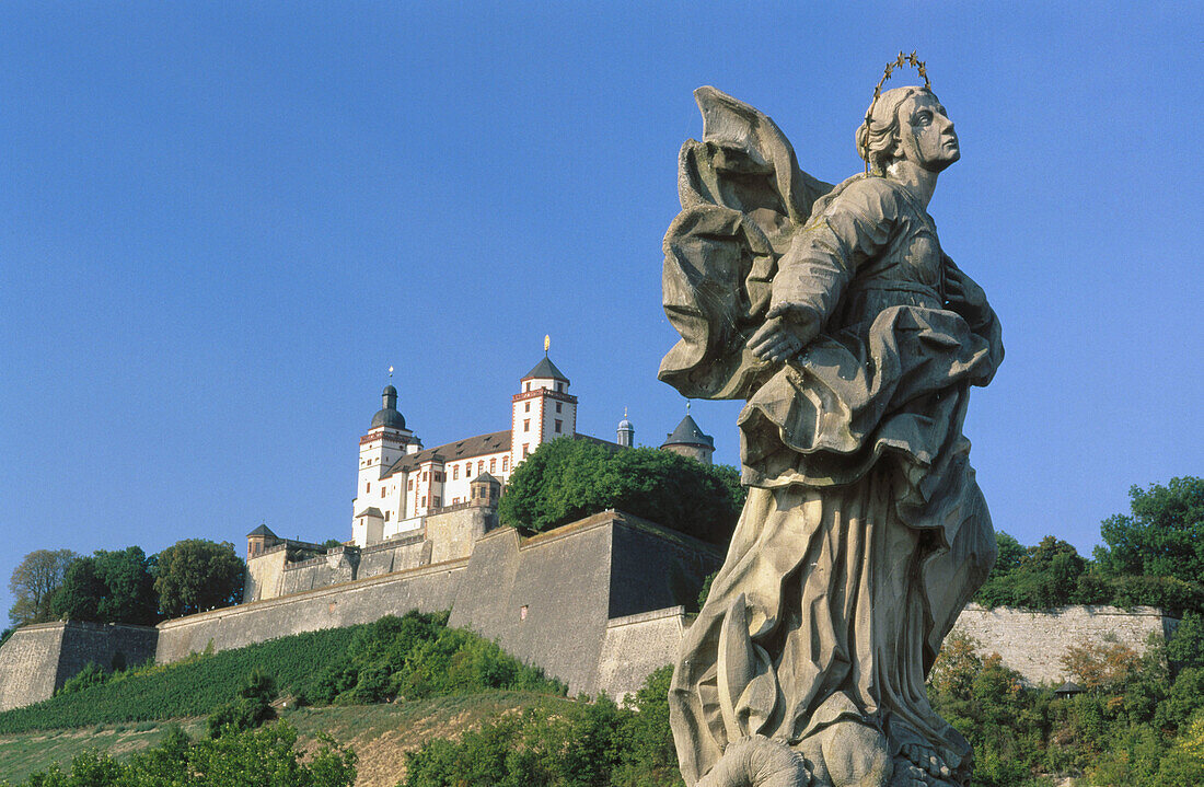 Sculpture on the Old Bridge (Alte Mainbrücke) over the Main River. Marienberg Castle at the background. Würzburg. Bavaria, Germany