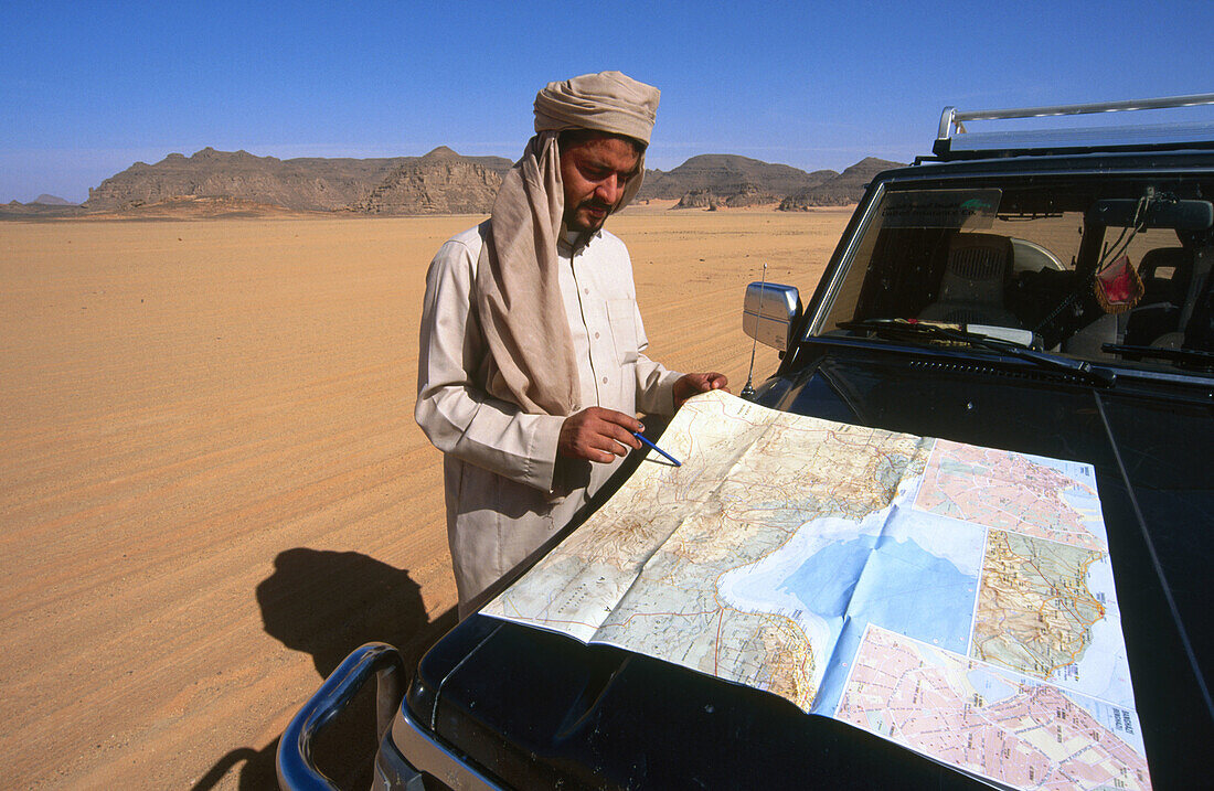 Driver checking map. Akakus, Fezzan. Sahara desert, Libya