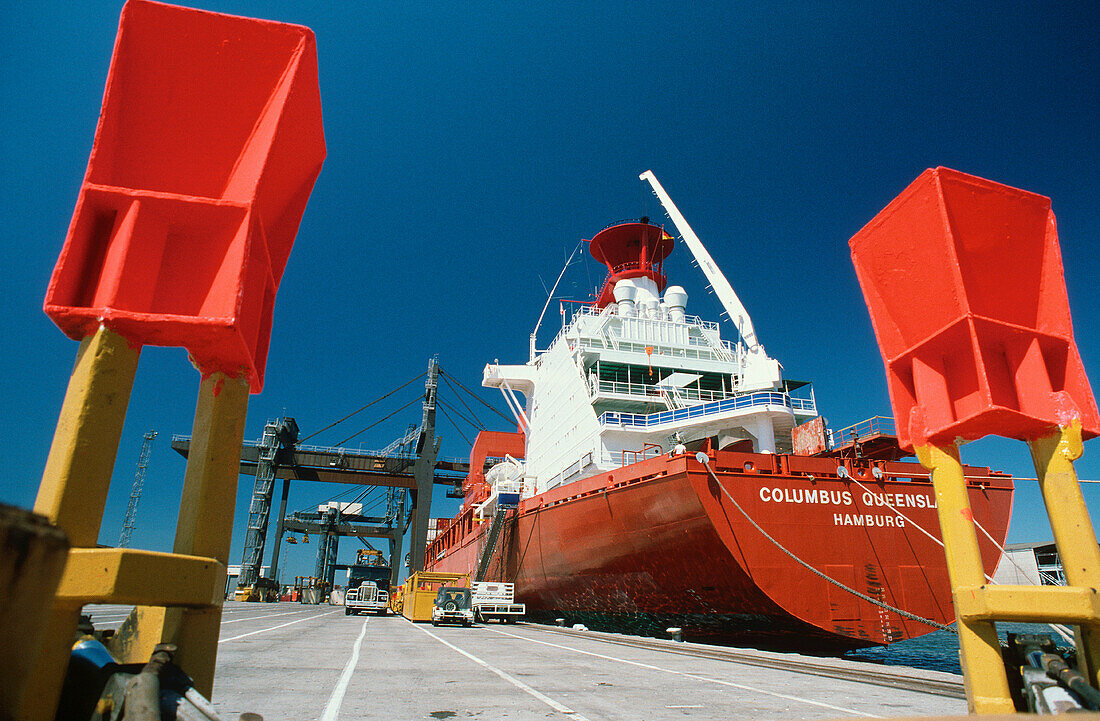 Container ship in dock with crane cradles foreground