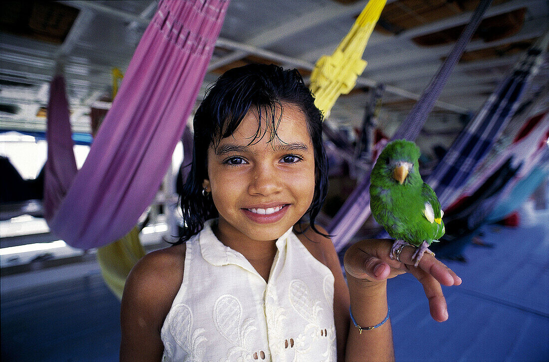 Little girl with parrot on the boat from Manaus to Belem. Amazon River. Brazil