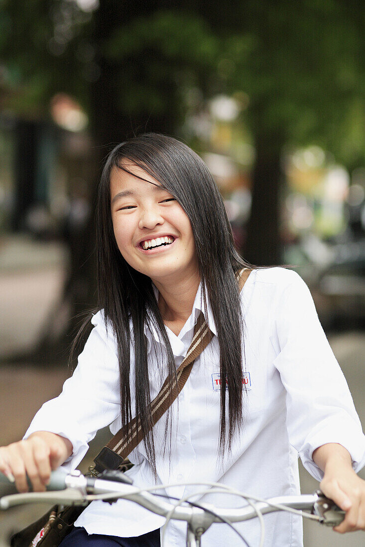 Portrait of teen smiling girl on bicycles. The Old Quarter, Hanoi, Vietnam, Indochina, Southeast Asia, Asia 2006