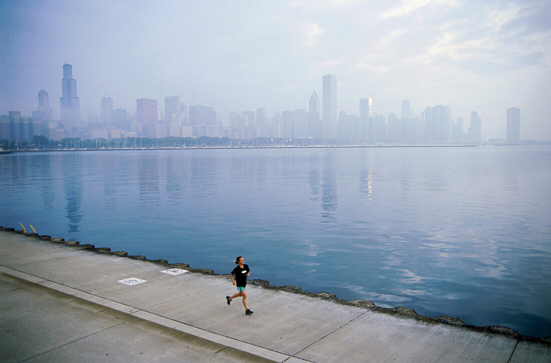 Young man jogging on shore of Lake Michigan, Northerly Island Park, Chicago, Illinois, USA