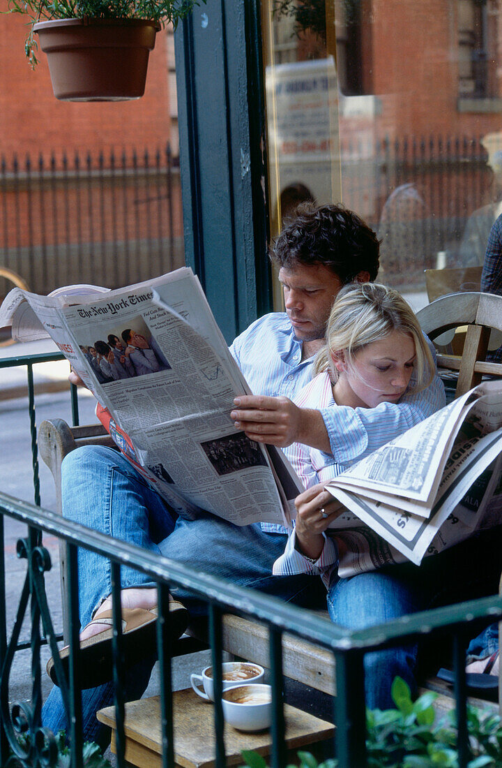 Couple reading newspaper in Café in Greenvich Village, Manhattan, New York, USA, America