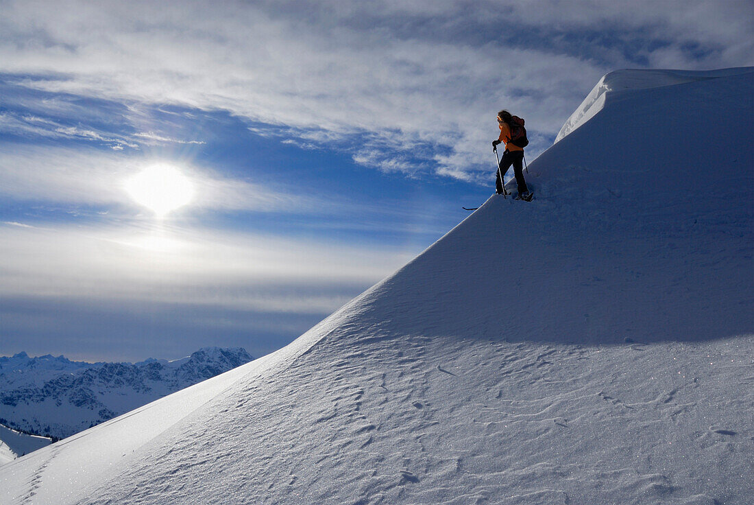 Skitourengeherin im Aufstieg am Grat mit Wechten, Allgäuer Alpen, Tirol, Österreich