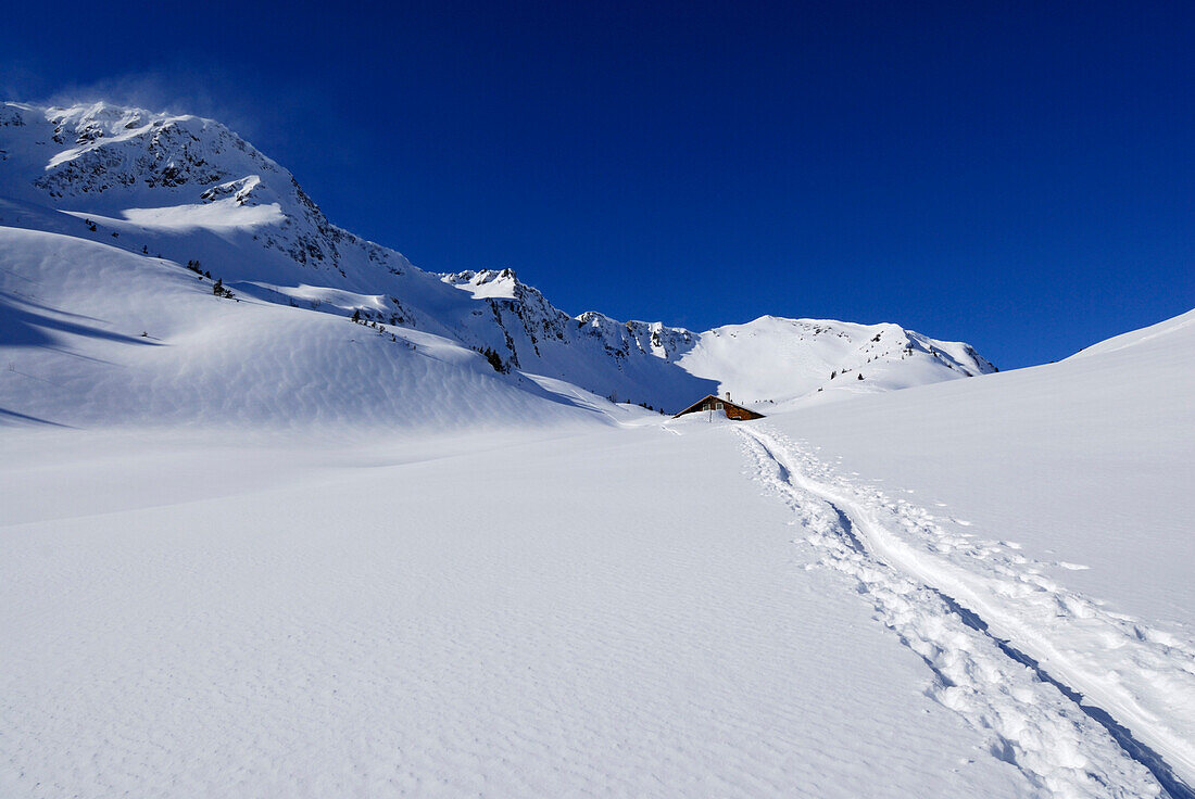 Ski track with alpine hut in background, Kleinwalsertal, Allgaeu Alps, Vorarlberg, Austria