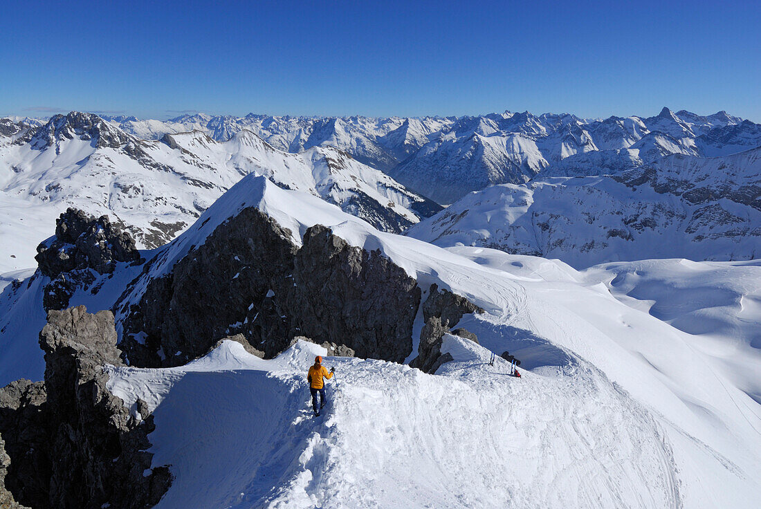 young woman descending from Mädelegabel with view to Lechtal range, Allgaeu range, Allgaeu, Swabia, Bavaria, Germany
