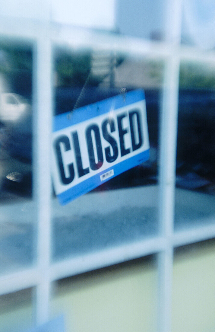 Closed sign hanging in shop window