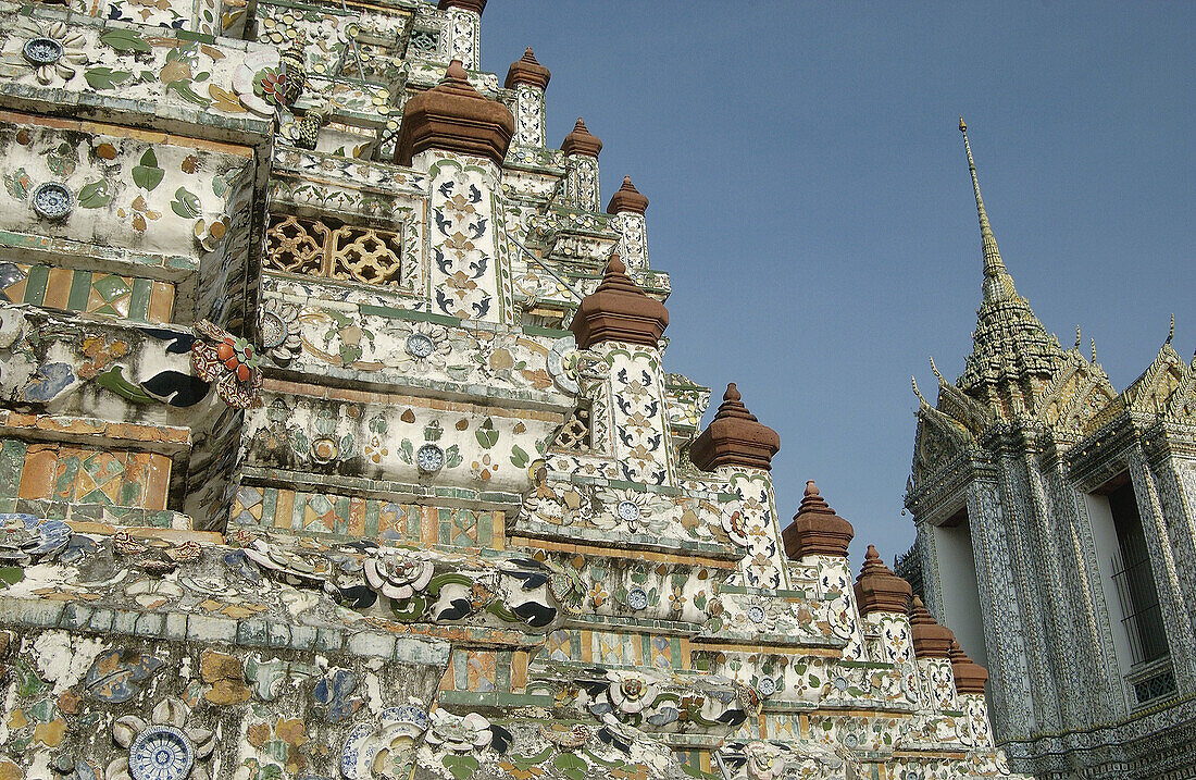 Close up on the tower plated with mosaic of porcelain pieces. Wat Arun temple (Temple of the Dawn). Bangkok. Thailand