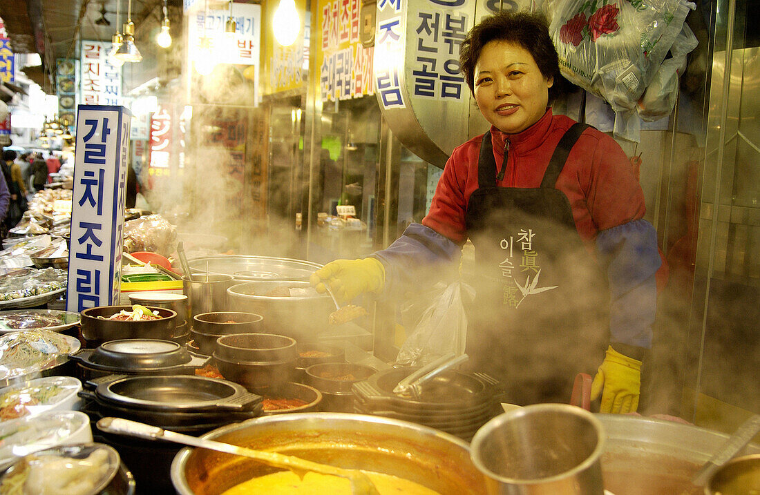 Woman selling food outside of restaurant in Namdaemon market. Seoul, South Korea.