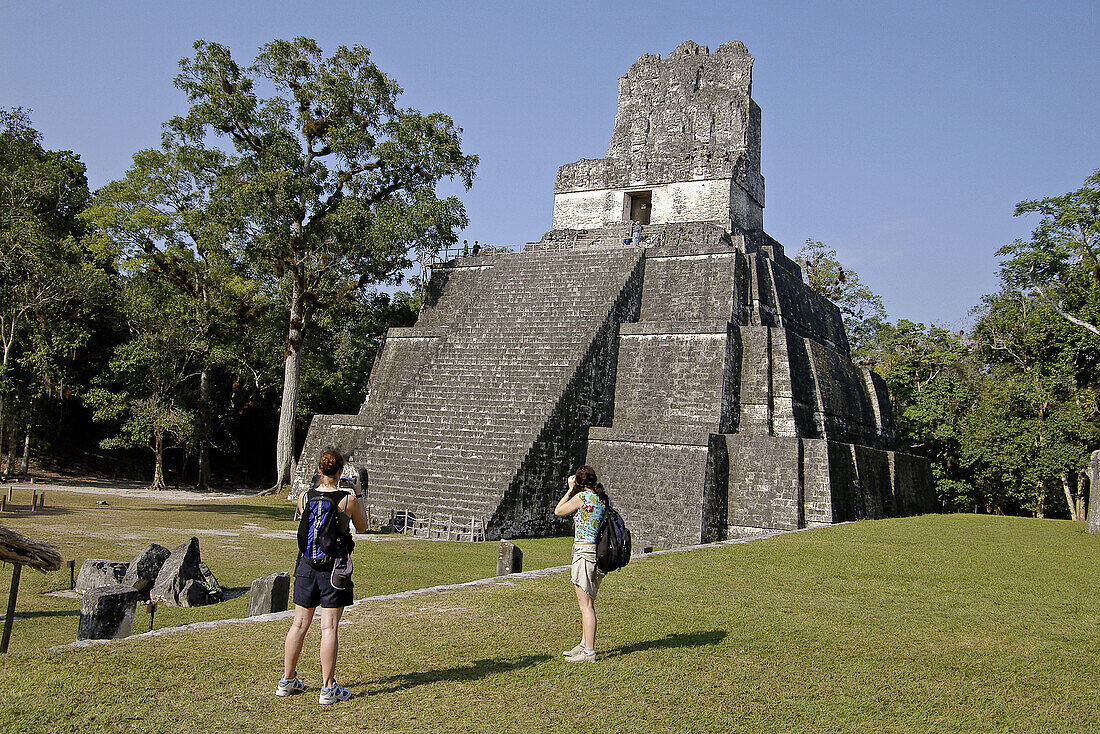 Tourists taking photos of Temple II. Mayan ruins of Tikal. Peten region, Guatemala