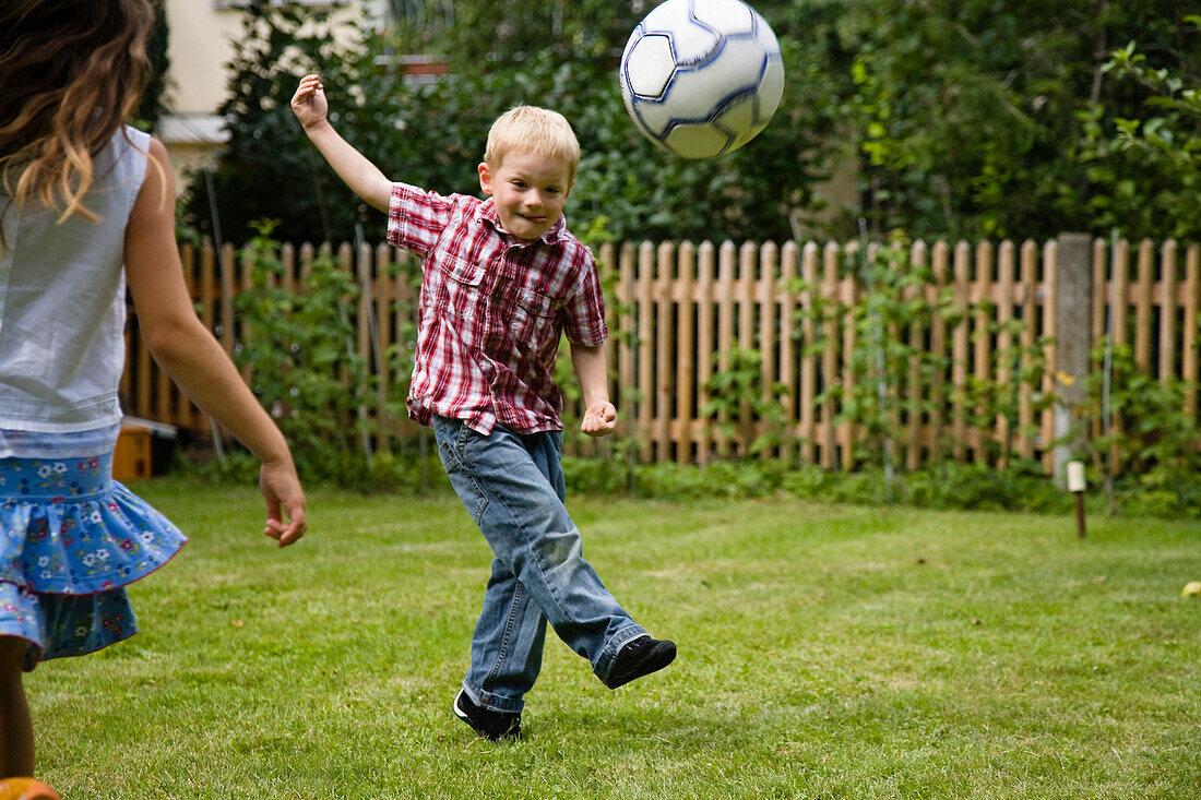 Kinder spielen Fußball im Garten, Oberbayern, Bayern, Deutschland