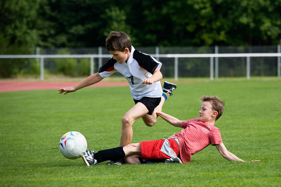 Zwei Jungen (7-8 Jahre) spielen Fußball, Oberbayern, Bayern, Deutschland