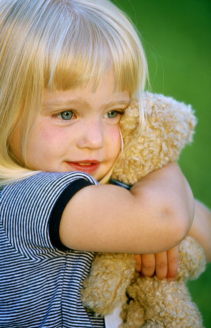 Little girl hugging her teddy bear