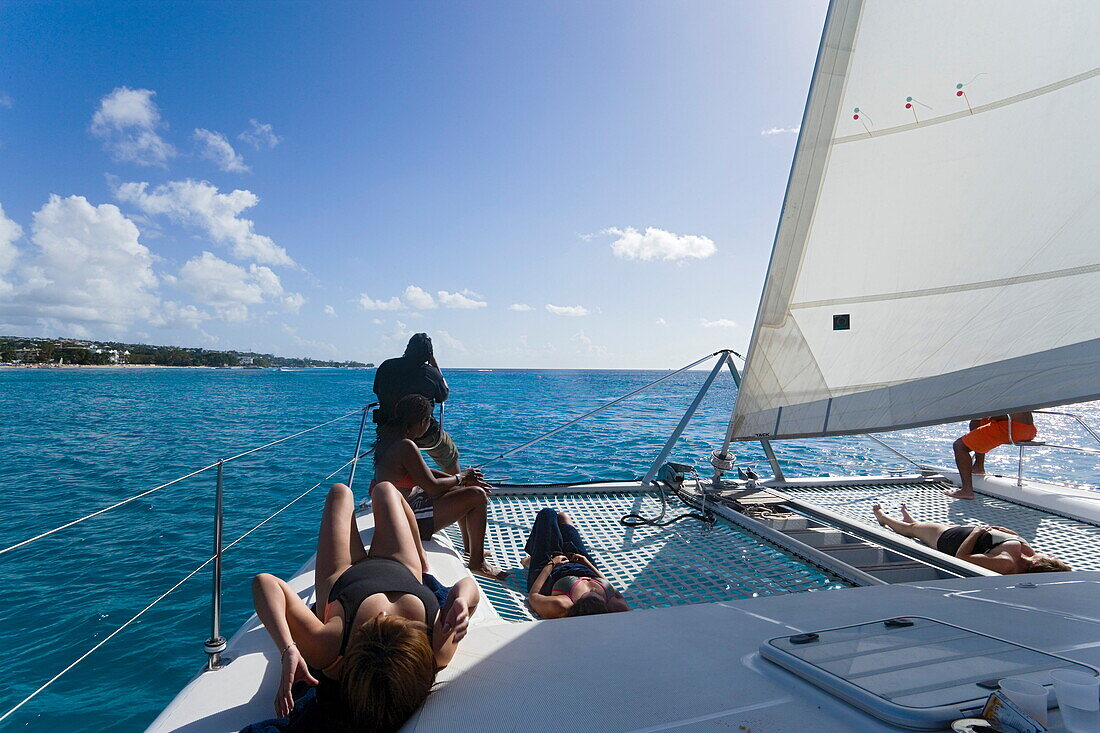 Women sunbathing on a catamaran, West Coast, Barbados, Caribbean