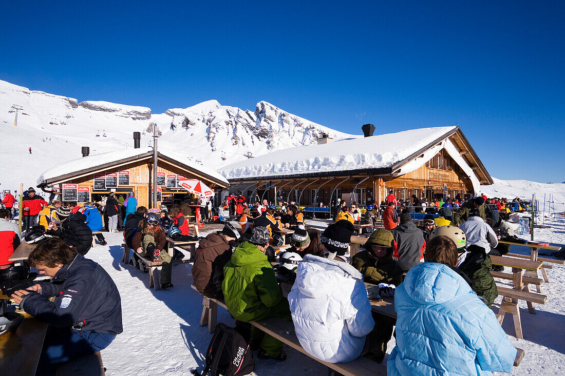 Tourists resting on terrace of mountain restaurant Schreckfeld, First, Grindelwald, Bernese Oberland, Canton of Bern, Switzerland