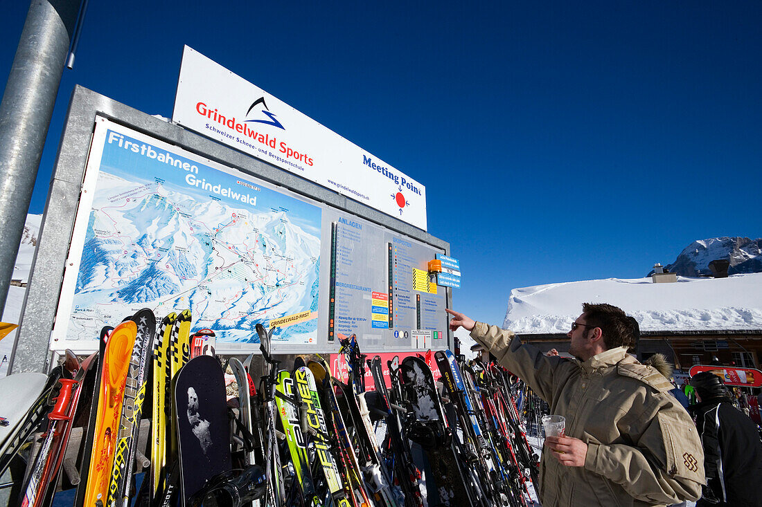 Skier reading a map at mountain restaurant Schreckfeld, First, Grindelwald, Bernese Oberland, Canton of Bern, Switzerland