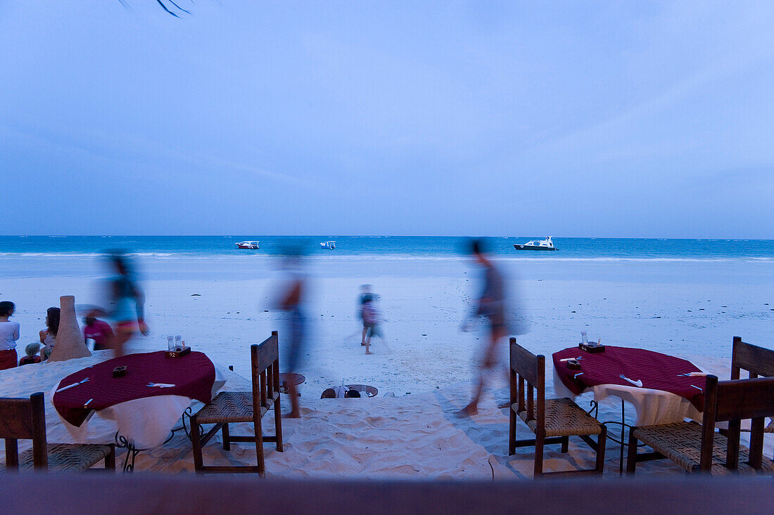 People passing a beach restaurant, The Sands, at Nomad, Diani Beach, Kenya