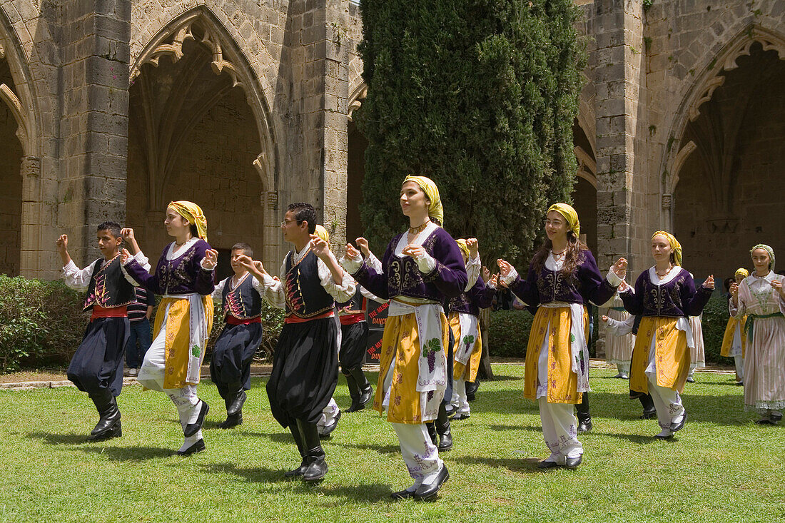 Local men and women in traditional costume dancing, folk dance, folklore, Bellapais Abbey, Beylerbeyi, Abbey de la Pais, monastery ruin, near Kyrenia, near Girne, North Cyprus, Cyprus