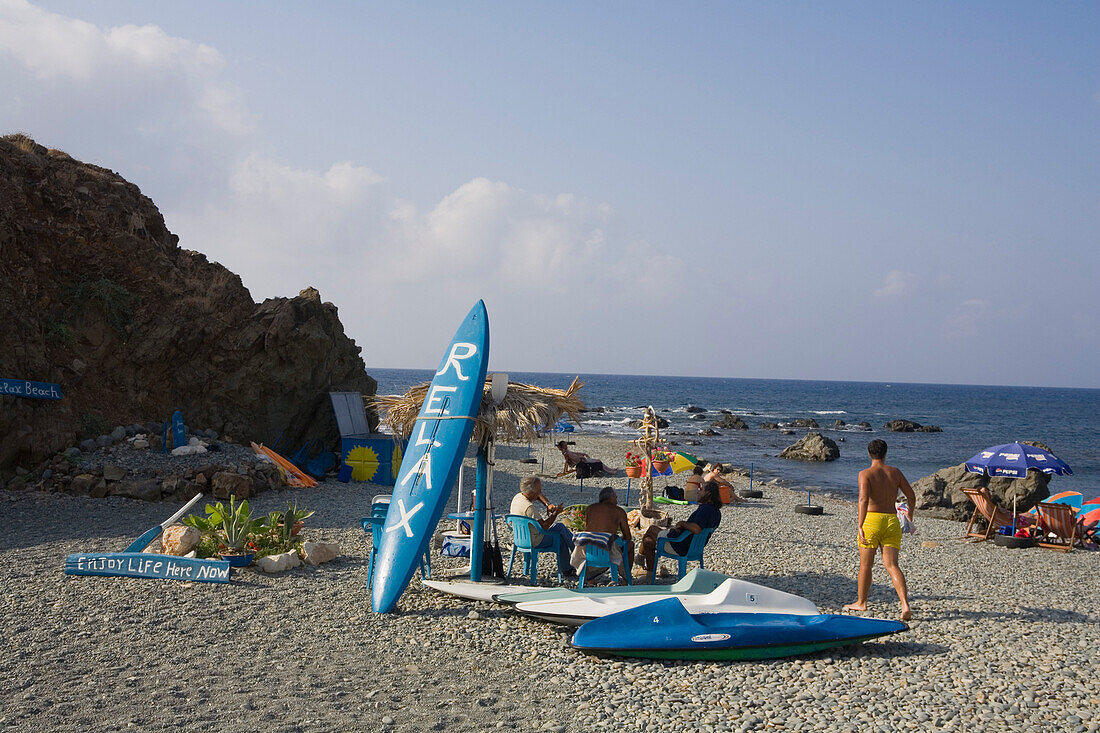 People relaxing on the beach Relax sign, Akro Pornos, near Polis, South Cyprus, Cyprus