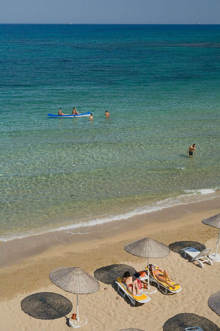 Two women sunbathing on Salamis Beach, Mimoza Beach Hotel, Salamis, North Cyprus, Cyprus