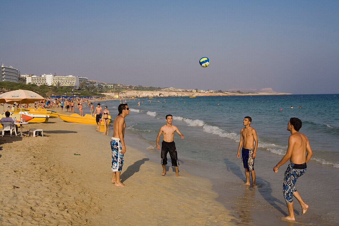 Vier junge Männer spielen mit einem Ball am Strand, Agia Napa, Strand, Meer, Mittelmeer
