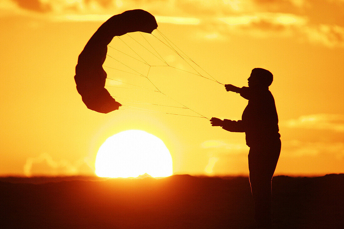 Boy playing with kite at sunset. Tarifa, Cádiz province. Andalusia, Spain