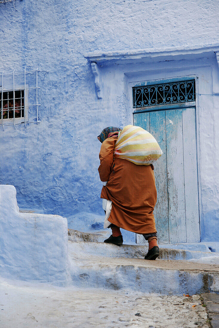 Woman in typical street in Chefchaouen, Morocco.