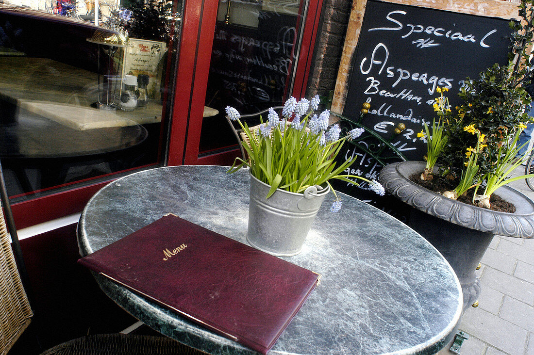 Restaurant table with menu and flower pot. Amsterdam. Holland