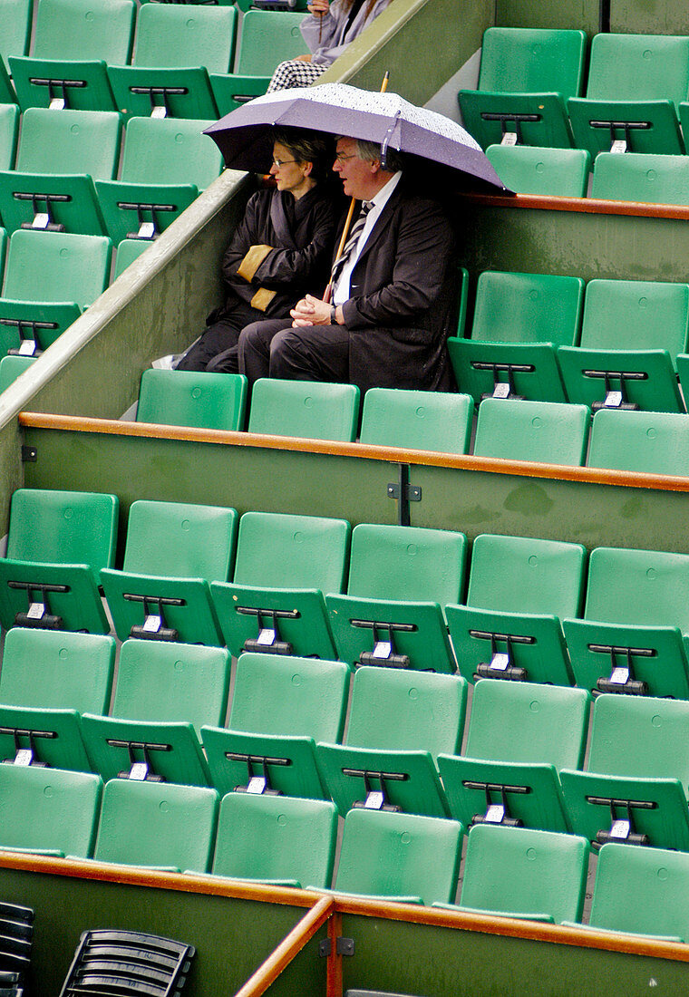 Two spectators under an umbrella at the French Open 2004. Paris. France
